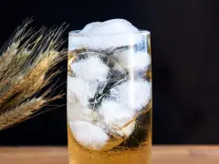 Ein erfrischender Whisky Soda mit viel Eis, daneben ein paar Ähren.