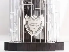Dom Pérignon Vintage 2012 in einer modernen, transparenten Hülle mit dunklem Holzsockel.