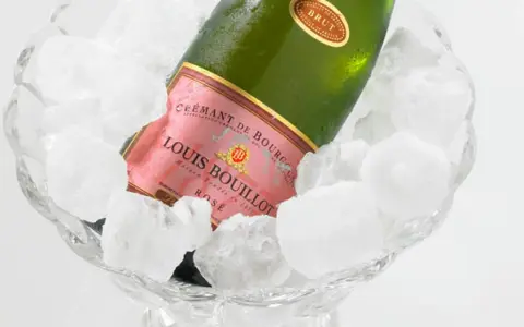 Flasche Louis Bouillot Rosé Crémant de Bourgogne in Eis gekühlt, perfekte Champagner Temperatur.