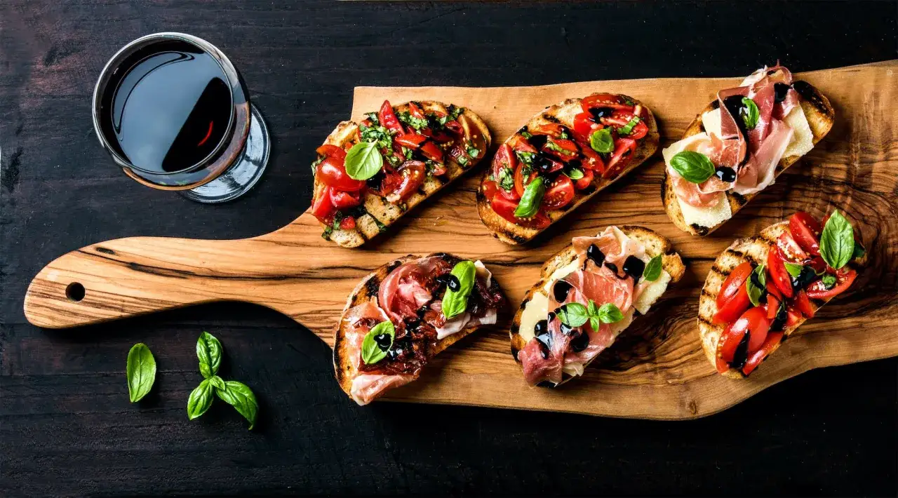 Bruschetta mit Tomaten und Prosciutto, ein Glas Rotwein. Ein doppelter Schritt in den Genuss italienischer Aromen.