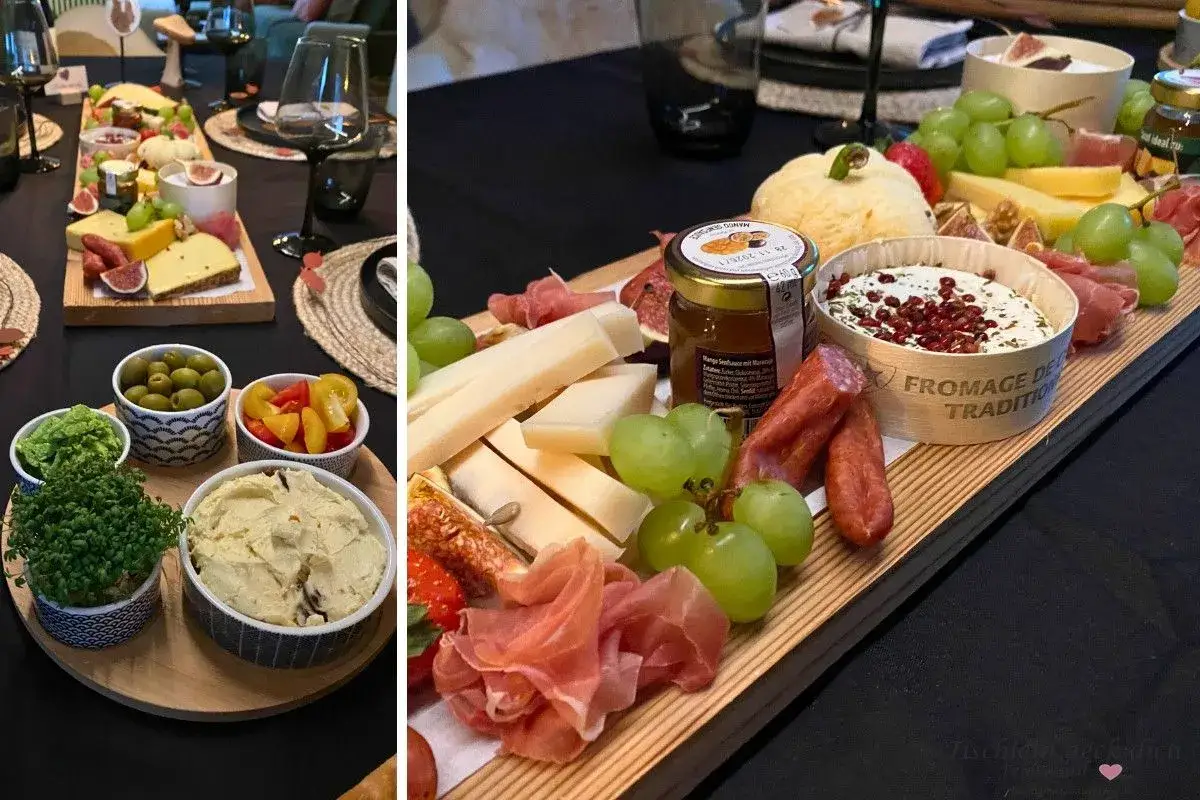 Ein k&ouml;stlicher weinabend mit freunden: K&auml;se, Trauben, Feigen, Aufschnitt und Dips auf einer Holzplatte.