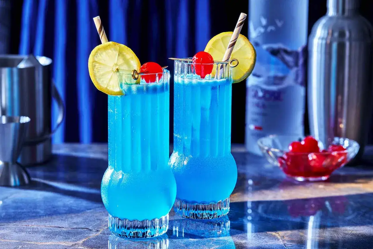 Zwei erfrischende Blue Lagoon Cocktails mit Zitrone und Kirsche, bereit f&uuml;r einen entspannten Abend.