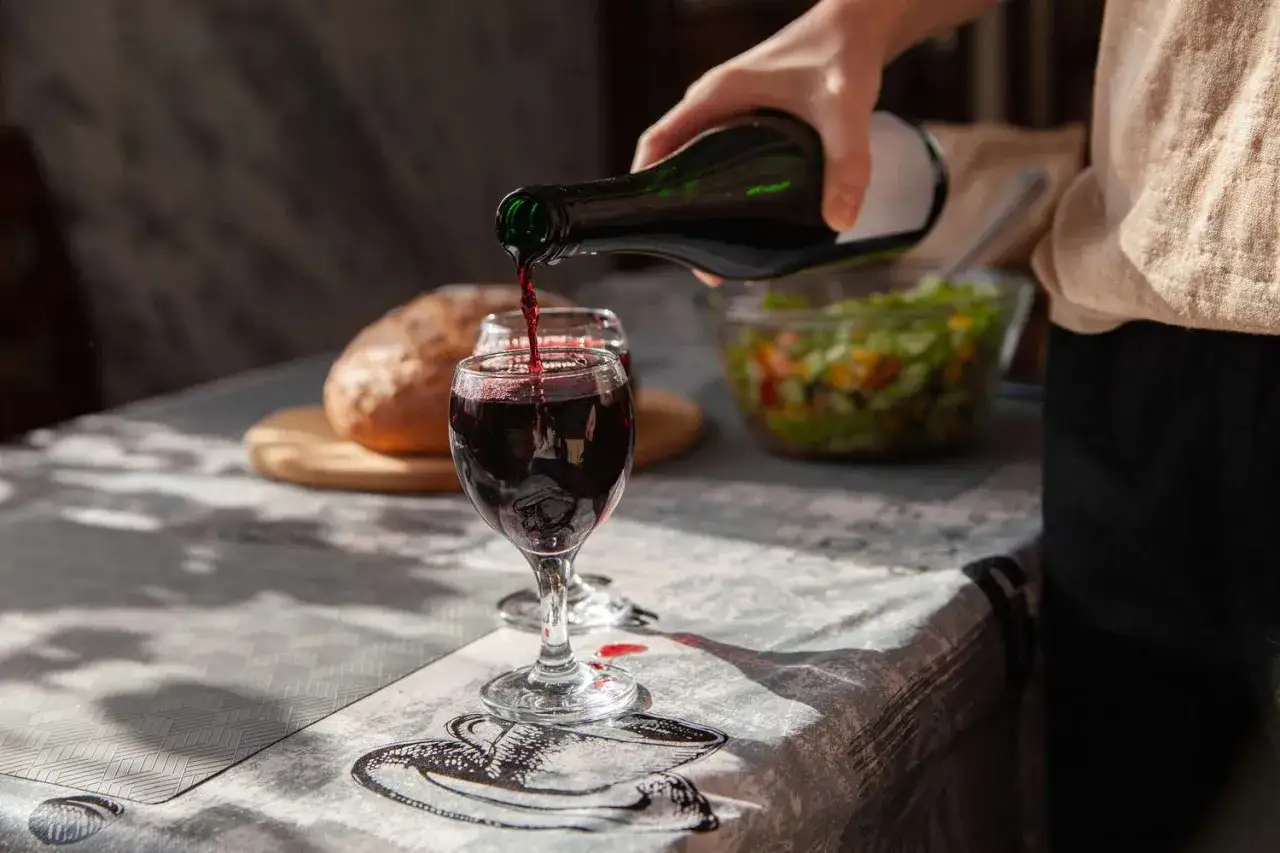 Rotwein wird in ein Glas gegossen. Der Nero d'Avola Geschmack passt perfekt zu Brot und Salat.